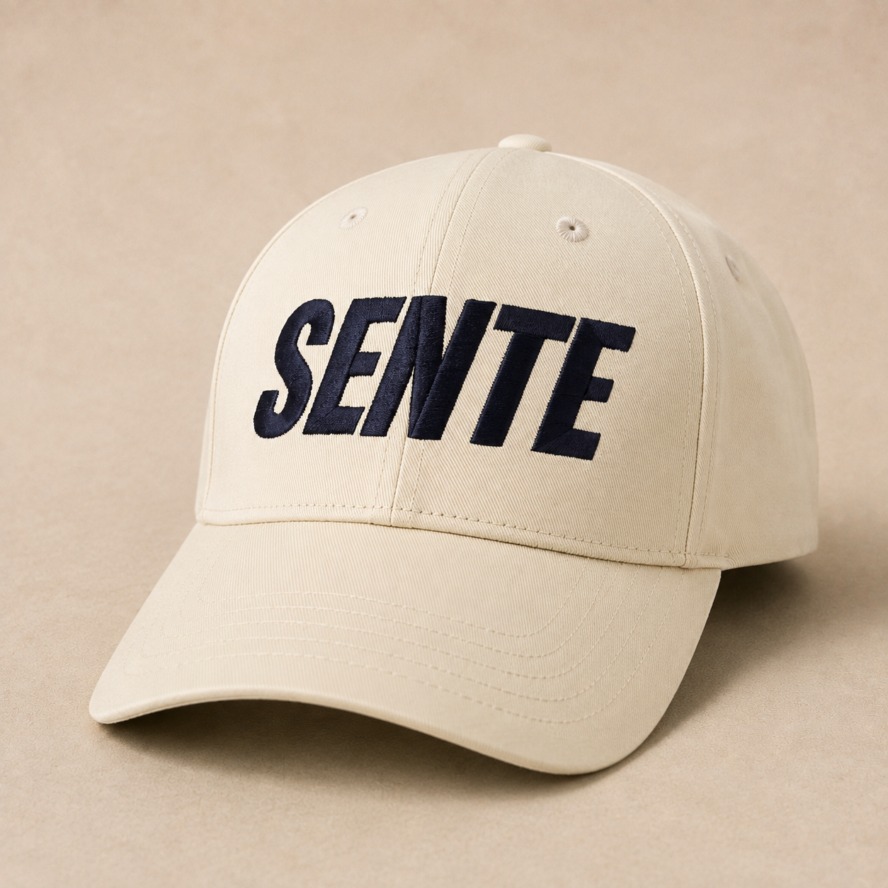 A beige baseball cap with the word 'SENTE' embroidered in bold navy blue letters across the front, set against a matching beige background.