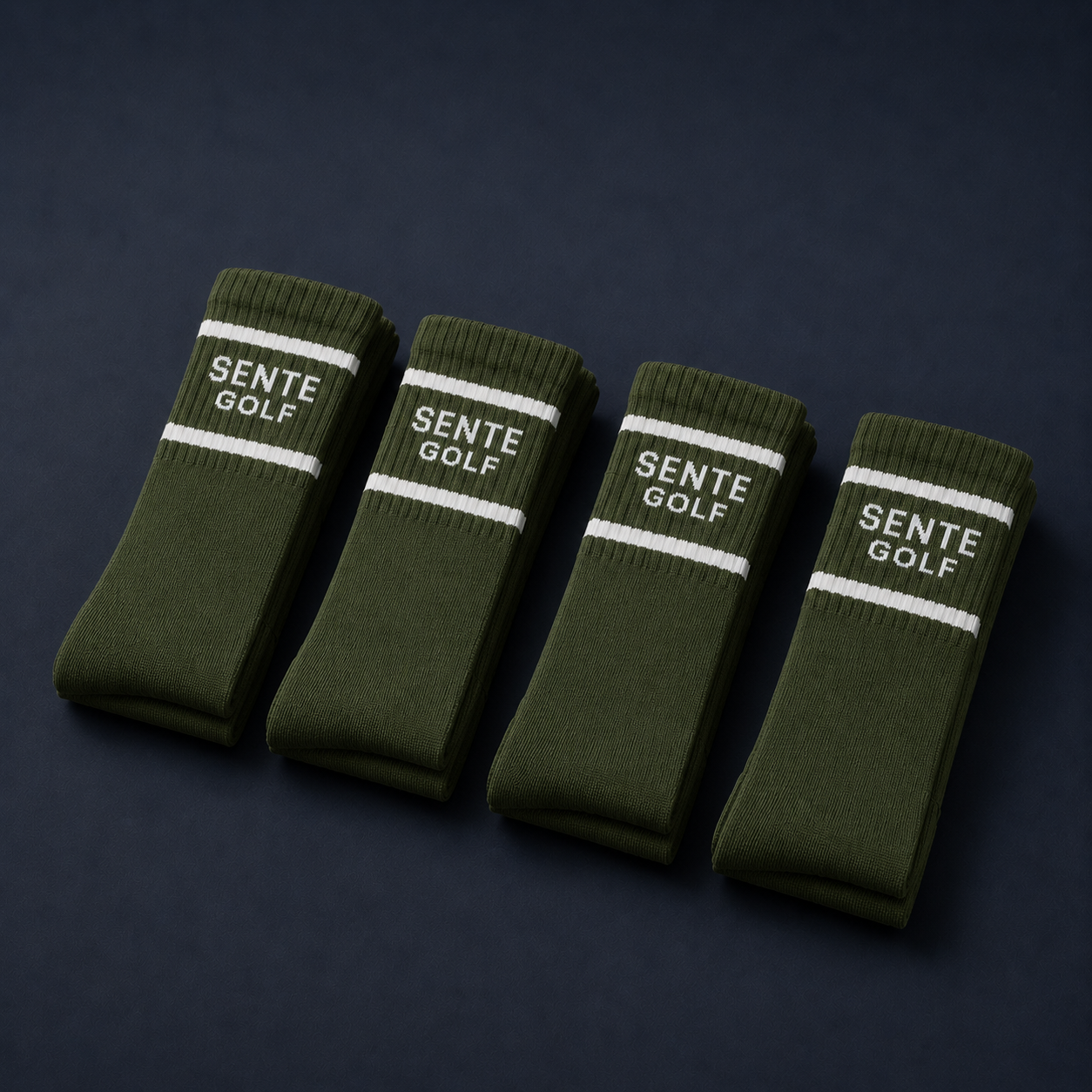 Four green socks with 'Sente Golf' branding on a dark background