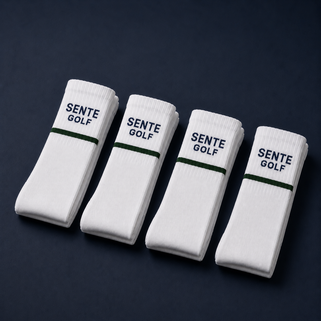 Four pairs of white socks with 'Sente Golf' branding on a dark background