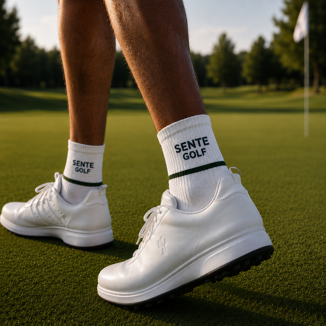 White golf shoes and socks with 'Sente Golf' branding on a golf course.